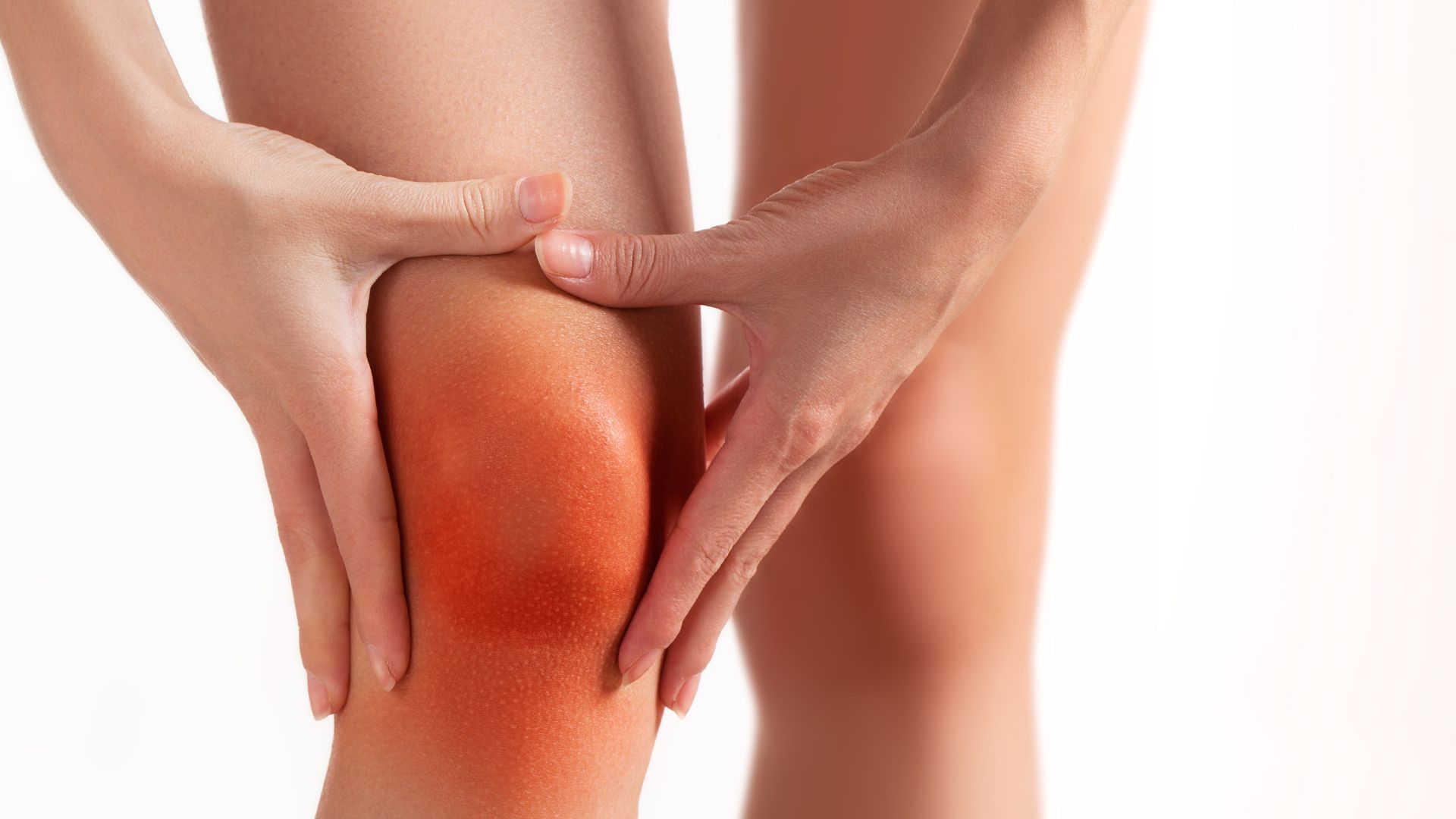 Close-up of inflamed knee held by both hands, red skin indicating joint pain or inflammation. Let me know if you'd like variants for arthritis awareness, injury recovery, or orthopedic care content.