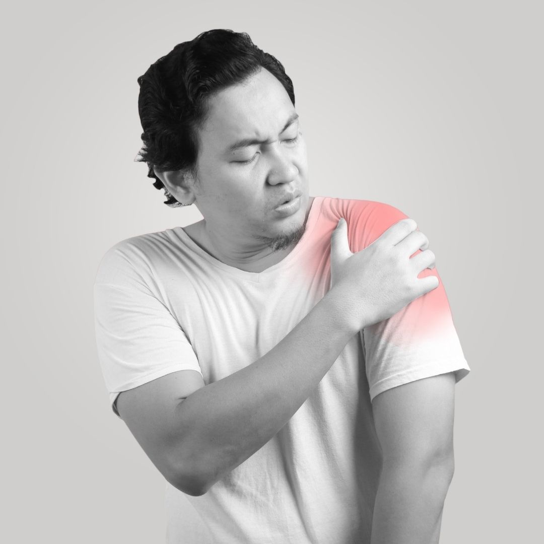 Person in white t-shirt holding left shoulder with visible red glow indicating pain and discomfort.