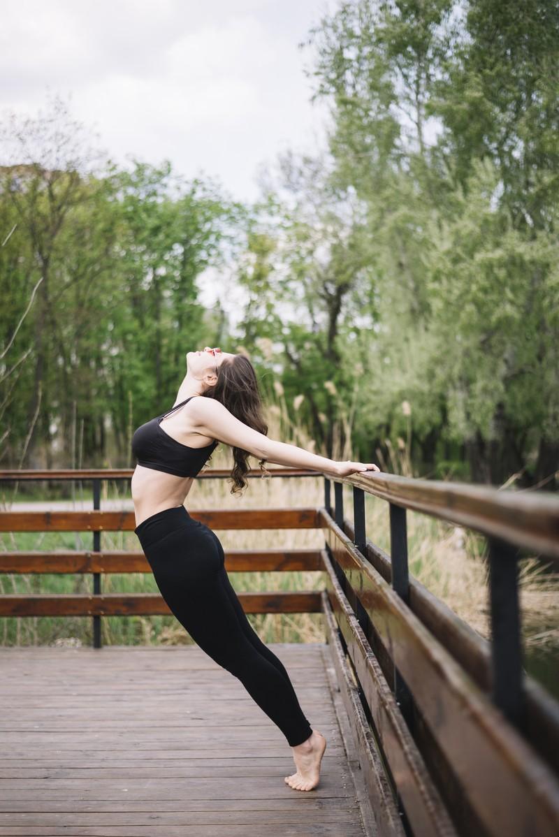 attractive-young-woman-doing-backbend-wooden-railing_5245431