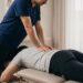 Chiropractor treating a patient's lower back on a treatment table