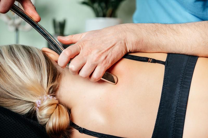 chiropractor-performing-myofascial-release-techniques-with-iastm-tool-rhomboids_20258132