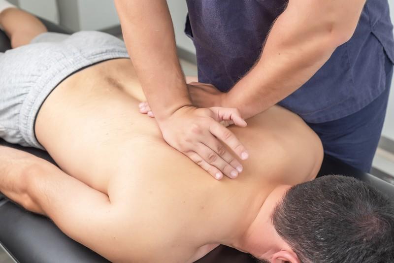 physiotherapist-massaging-patient-s-back_22760069