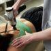 delivering-massage-therapy-with-electronic-massager-device_397313185.jpg